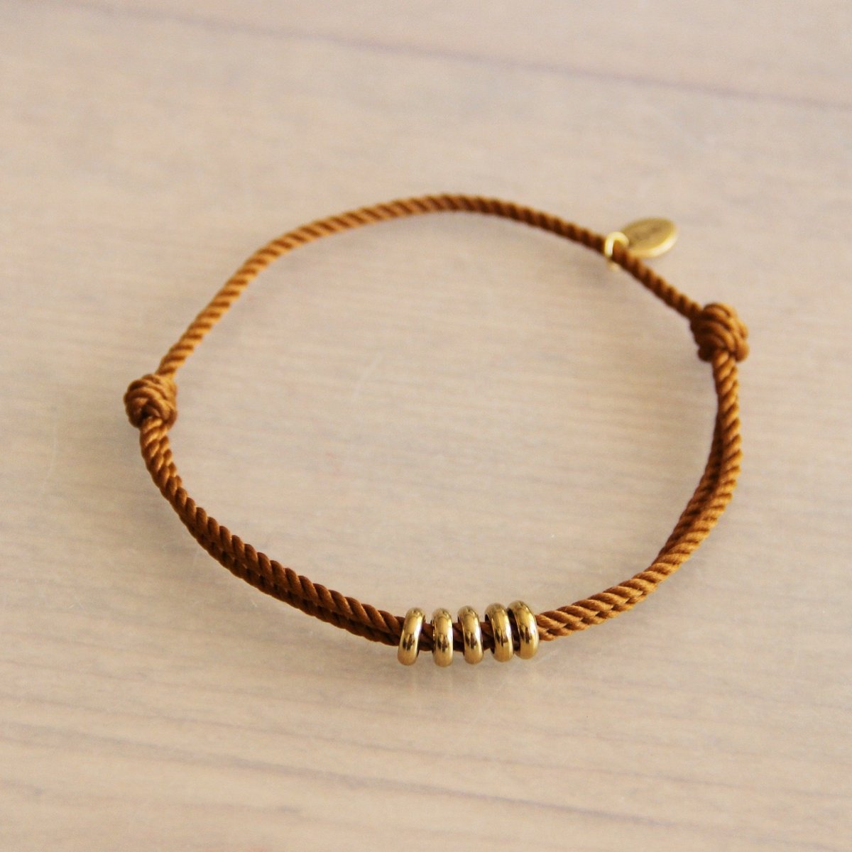 Gedraaid koord armband met ringen- roestbruin/goud